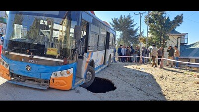 A HRTC bus stuck in a pit caused after a portion of the road caved in at Bhattakufer in Shimla on Saturday. (Deepak Sansta/HT) A HRTC bus stuck in a pit caused after a portion of the road caved in at Bhattakufer in Shimla on Saturday. (Deepak Sansta/HT)
