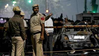 Police personnel stand beside charred vehicles at the blast site after an explosion near the Red Fort in the old quarters of Delhi. (AFP) Police personnel stand beside charred vehicles at the blast site after an explosion near the Red Fort in the old quarters of Delhi. (AFP)
