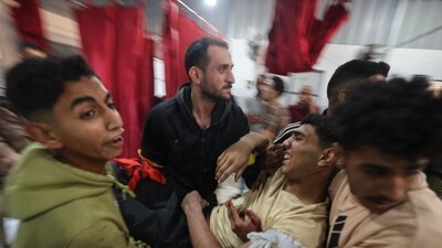 Palestinians carry an injured man at Al-Awda Hospital at the Nuseirat refugee camp in the central Gaza Strip, as casualties are brought into the medical facility following Israeli strikes on November 22, 2025. (AFP) Palestinians carry an injured man at Al-Awda Hospital at the Nuseirat refugee camp in the central Gaza Strip, as casualties are brought into the medical facility following Israeli strikes on November 22, 2025. (AFP)