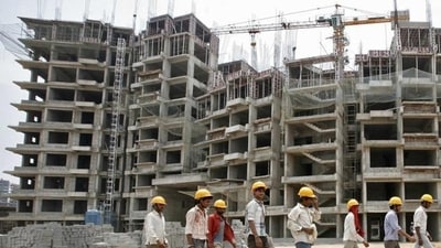 Workers walk in front of the construction site of a commercial complex outside Ahmedabad (REUTERS) Workers walk in front of the construction site of a commercial complex outside Ahmedabad (REUTERS)