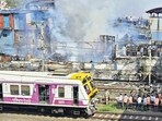 Mumbai, India - Nov. 22, 2025: Railway commuters walk on track as the fire brigade personnel doused the fire at hutment of Narang compound, Dharavi, in Mumbai, India, on Saturday, November 22, 2025. (Photo by Anshuman Poyrekar/Hindustan Times) (Anshuman Poyrekar/HT Photo)