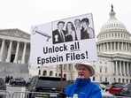 WASHINGTON, DC - NOVEMBER 18: A protester holds a placard after the House voted 427-1 to approve the Epstein Files Transparency Act and the release of documents and files at the U.S. Capitol on November 18, 2025 in Washington, DC. (Photo by ROBERTO SCHMIDT / GETTY IMAGES NORTH AMERICA / Getty Images via AFP) WASHINGTON, DC - NOVEMBER 18: A protester holds a placard after the House voted 427-1 to approve the Epstein Files Transparency Act and the release of documents and files at the U.S. Capitol on November 18, 2025 in Washington, DC. (Photo by ROBERTO SCHMIDT / GETTY IMAGES NORTH AMERICA / Getty Images via AFP)