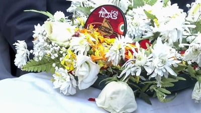 A wreath lies on the coffin of wing commander Namansh Syal in Kangra on Sunday. Syal died on November 21 after the Tejas LCA he was flying lost control, plunged and caught fire in Dubai. (ANI Video Grab) A wreath lies on the coffin of wing commander Namansh Syal in Kangra on Sunday. Syal died on November 21 after the Tejas LCA he was flying lost control, plunged and caught fire in Dubai. (ANI Video Grab)