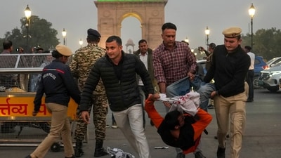 Police and security personnel detain a protestor during a protest against worsening air quality in the national capital, near the India Gate, in New Delhi, Sunday, Nov. 23, 2025. (PTI) Police and security personnel detain a protestor during a protest against worsening air quality in the national capital, near the India Gate, in New Delhi, Sunday, Nov. 23, 2025. (PTI)