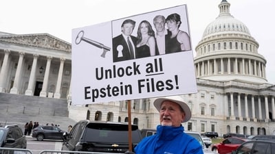 WASHINGTON, DC - NOVEMBER 18: A protester holds a placard after the House voted 427-1 to approve the Epstein Files Transparency Act and the release of documents and files at the U.S. Capitol on November 18, 2025 in Washington, DC. (Photo by ROBERTO SCHMIDT / GETTY IMAGES NORTH AMERICA / Getty Images via AFP) (Getty Images via AFP) WASHINGTON, DC - NOVEMBER 18: A protester holds a placard after the House voted 427-1 to approve the Epstein Files Transparency Act and the release of documents and files at the U.S. Capitol on November 18, 2025 in Washington, DC. (Photo by ROBERTO SCHMIDT / GETTY IMAGES NORTH AMERICA / Getty Images via AFP) (Getty Images via AFP)