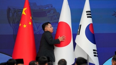 FILE PHOTO: A staff member organises flags of China, Japan and Korea before the start of the 28th ASEAN Plus Three Summit in Kuala Lumpur, Malaysia. (REUTERS)