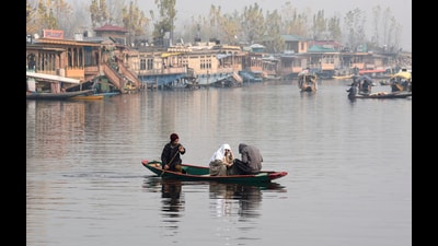 People enjoy a Shikara ride on a cold foggy morning at Dal Lake, in Srinagar on Monday. (ANI)