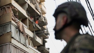 People inspect a damaged building, after Israeli military said on Sunday that it struck a militant from the Lebanese Iran-aligned Hezbollah group, in Beirut's southern suburbs, Lebanon (Reuters)