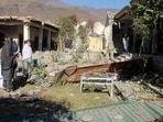People stand in front of damaged houses that the Afghan Taliban government said were damaged after Pakistan carried out raids