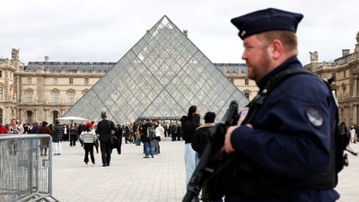 French CRS riot police officers were seen patrolling near the glass Pyramid of the Louvre Museum, after French police arrested suspects in the Louvre heist case, in Paris (Reuters)