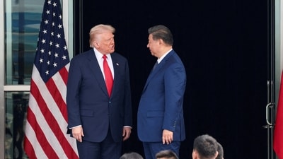 US President Donald Trump and Chinese President Xi Jinping talk as they leave after a bilateral meeting in Busan, South Korea, in October (REUTERS)