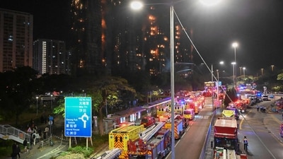 Fire trucks and rescue vehicles line a road during a major fire at the Wang Fuk Court residential estate (background) in Hong Kong's Tai Po district on November 26, 2025. (AFP) Fire trucks and rescue vehicles line a road during a major fire at the Wang Fuk Court residential estate (background) in Hong Kong's Tai Po district on November 26, 2025. (AFP)