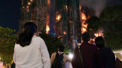 People look on as thick smoke and flames rise during a major fire at the Wang Fuk Court residential estate. (AFP) People look on as thick smoke and flames rise during a major fire at the Wang Fuk Court residential estate. (AFP)