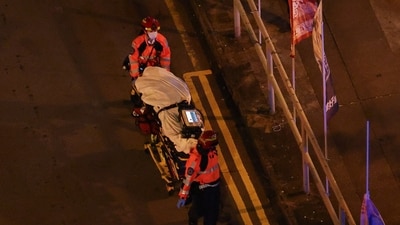 First responders recover the body of a victim, as fire burns bamboo scaffolding across multiple buildings at Wang Fuk Court housing estate, in Tai Po, Hong Kong. (REUTERS)