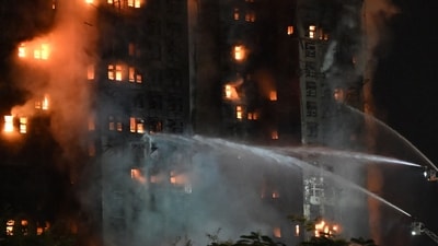 Firefighters spray water during a major fire at the Wang Fuk Court residential estate in Hong Kong's Tai Po district on November 26. (Photo by Peter PARKS / AFP) (AFP) Firefighters spray water during a major fire at the Wang Fuk Court residential estate in Hong Kong's Tai Po district on November 26. (Photo by Peter PARKS / AFP) (AFP)