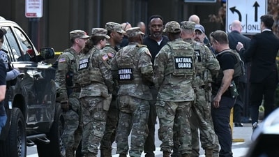 National Guard soldiers huddle around law enforcement officers while receiving information after a shooting in downtown Washington, DC, on November 26, 2025. (AFP) National Guard soldiers huddle around law enforcement officers while receiving information after a shooting in downtown Washington, DC, on November 26, 2025. (AFP)