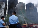 Police officers stand guard at the scene of a fire which broke out Wednesday at Wang Fuk Court, a residential estate in the Tai Po district of Hong Kong's New Territories.
