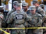 National Guard members stand together behind yellow tape, after two National Guard members were shot near the White House.