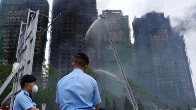 Police officers stand guard at the scene of a fire which broke out Wednesday at Wang Fuk Court, a residential estate in the Tai Po district of Hong Kong's New Territories. (AP) Police officers stand guard at the scene of a fire which broke out Wednesday at Wang Fuk Court, a residential estate in the Tai Po district of Hong Kong's New Territories. (AP)