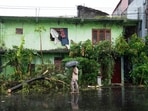 A tree is uprooted in front of a residential building partially damaged by heavy rains in Colombo, Sri Lanka, Friday, Nov. 28, 2025.