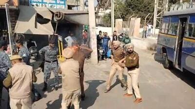 A video grab of Punjab Police personnel rushing to the rescue of Dhuri station house officer Jasvir Singh, who suffered burns after his uniform caught fire during the clash with protesters, outside the Sangrur bus stand on Friday morning. Some of the protesters were carrying bottles of petrol while sitting atop buses. A video grab of Punjab Police personnel rushing to the rescue of Dhuri station house officer Jasvir Singh, who suffered burns after his uniform caught fire during the clash with protesters, outside the Sangrur bus stand on Friday morning. Some of the protesters were carrying bottles of petrol while sitting atop buses.