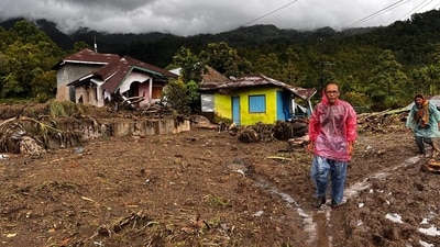 People walk past damaged houses at a village affected by flood in Malalak, West Sumatra, Indonesia. (AP) People walk past damaged houses at a village affected by flood in Malalak, West Sumatra, Indonesia. (AP)