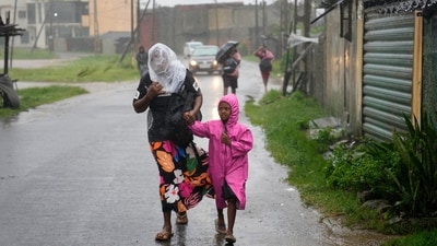 A woman and child walk under a downpour in Colombo, Sri Lanka, Friday, Nov. 28, 2025. (AP) A woman and child walk under a downpour in Colombo, Sri Lanka, Friday, Nov. 28, 2025. (AP)