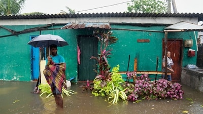 A man walks on a flooded street as a woman stands at the entrance to her home in Colombo, Sri Lanka, Friday, Nov. 28, 2025. (AP) A man walks on a flooded street as a woman stands at the entrance to her home in Colombo, Sri Lanka, Friday, Nov. 28, 2025. (AP)