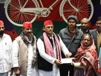 SP chief Akhilesh Yadav handing over a cheque of <span class='webrupee'>₹</span>2-lakh ex gratia to the dependents of a deceased BLO, in Lucknow on Saturday. (HT Photo) SP chief Akhilesh Yadav handing over a cheque of <span class='webrupee'>₹</span>2-lakh ex gratia to the dependents of a deceased BLO, in Lucknow on Saturday. (HT Photo)