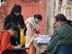 Voters completing SIR form at Clock Tower in Lucknow on Saturday. (HT)