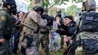 An ICE agent points a crowd control weapon at a protester. (AP) An ICE agent points a crowd control weapon at a protester. (AP)