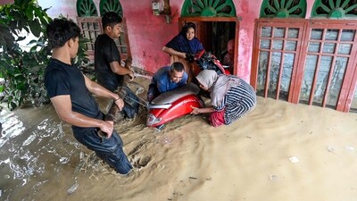 Residents are seen moving a motorcycle amid flash floods in Indonesia's Aceh province on Friday after days of devastating flooding across Southeast Asia killed more than 300 people in Indonesia, Thailand and Malaysia. Koto, a fast-building tropical storm that swept into Thailand from the Gulf, brought intense rain and fierce winds that disrupted daily life across several provinces. (AFP Photo) Residents are seen moving a motorcycle amid flash floods in Indonesia's Aceh province on Friday after days of devastating flooding across Southeast Asia killed more than 300 people in Indonesia, Thailand and Malaysia. Koto, a fast-building tropical storm that swept into Thailand from the Gulf, brought intense rain and fierce winds that disrupted daily life across several provinces. (AFP Photo)