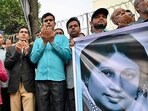 Activists in support of Bangladesh's former prime minister Khaleda Zia hold a banner with her portrait as they pray for her recovery in front of Evercare Hospital in Dhaka on November 29, 2025. Zia, 80, was admitted to hospital on November 23 with symptoms of a lung infection and is currently undergoing treatment in the intensive care unit (ICU), members of her party said.