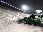 Field crew member clears snow off the field during the game between the Northwestern Wildcats and the Illinois Fighting Illini at Memorial Stadium on November 29, 2025 in Champaign, Illinois.