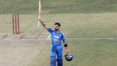 India's Virat Kohli raises his bat as he celebrates his century. (@BCCI X)