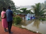 People look towards a house partially submersed by the flood, following Cyclone Ditwah in Peliyagoda, Sri Lanka, December 1, 2025.