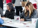 US First Lady Melania Trump (R) and Second Lady Usha Vance write notes to place into a care package for deployed members of the US military during an American Red Cross holiday event with military families at Joint Base Andrews in Maryland, December 1, 2025.(AFP)