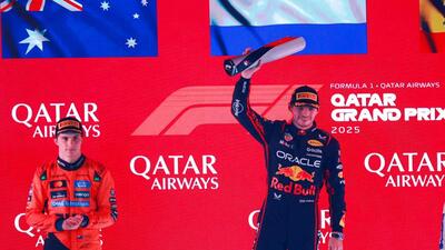 Red Bull Racing's Max Verstappen (R) celebrates with the trophy next to second placed McLaren's Oscar Piastri (L). (AFP) Red Bull Racing's Max Verstappen (R) celebrates with the trophy next to second placed McLaren's Oscar Piastri (L). (AFP)