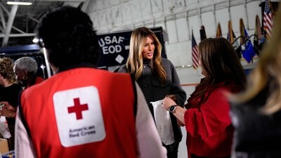 JOINT BASE ANDREWS, MARYLAND - DECEMBER 01: First lady Melania Trump helps make Red Cross holiday care packages during an event inside a hangar on December 1, 2025, at Joint Base Andrews, Maryland. The event is part of the American Red Cross Service to the Armed Forces (SAF), which supports the military, veterans and their families. (Getty Images via AFP) JOINT BASE ANDREWS, MARYLAND - DECEMBER 01: First lady Melania Trump helps make Red Cross holiday care packages during an event inside a hangar on December 1, 2025, at Joint Base Andrews, Maryland. The event is part of the American Red Cross Service to the Armed Forces (SAF), which supports the military, veterans and their families. (Getty Images via AFP)