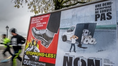 Voting posters in favor and against an initiative to tax the super-rich to help to finance the country's effort against climate change is seen in a street in Geneva, on November 25. Voting posters in favor and against an initiative to tax the super-rich to help to finance the country's effort against climate change is seen in a street in Geneva, on November 25.