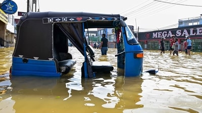 An auto rickshaw lies stranded as people wade through a flooded street after heavy rainfall in Wellampitiya on the outskirts of Sri Lanka's Colombo on November 30 (AFP) An auto rickshaw lies stranded as people wade through a flooded street after heavy rainfall in Wellampitiya on the outskirts of Sri Lanka's Colombo on November 30 (AFP)