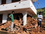 People stand next to debris near a damaged house after landslides caused by heavy rainfall following Cyclone Ditwah in Kandy, Sri Lanka, December 2, 2025. 