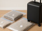 Neatly packed vacuum bags are placed beside a suitcase, ready for smoother travel and sorted seasonal storage.(AI generated)