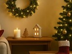 Soft festive lights glow around wreaths and cosy accents that bring a gentle Christmas feel to a home ready for the season.(AI generated)