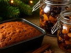 A tray of golden Christmas cakes rests beside jars of soaked fruits, bringing the festive baking, warmth, and holiday charm to the home.(Ai Generated)