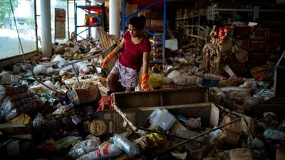 A woman cleans a wholesale store following deadly flooding in Hat Yai district, Songkhla province, Thailand. (REUTERS)