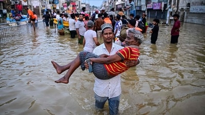 A youth carries an elderly man as they wade through a flooded street after heavy rainfall in Wellampitiya on the outskirts of Colombo. The floods and landslides were triggered by Cyclone Ditwah. (AFP) A youth carries an elderly man as they wade through a flooded street after heavy rainfall in Wellampitiya on the outskirts of Colombo. The floods and landslides were triggered by Cyclone Ditwah. (AFP)