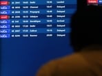 A man looks at a flight schedule screen displaying several delayed flights by IndiGo airlines at the Chhatrapati Shivaji Maharaj International Airport in Mumbai.
