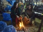 People seen sitting around a bonfire at Kalagram, Chandigarh, amid the dropping temperatures on Friday. (SANT ARORA/HT)