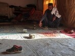 A man sits next to the blood-stained floor inside his damaged house in Chaman on December 6, 2025, following overnight cross-border fire between Pakistan and Afghanistan.